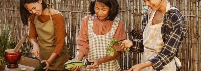 Happy Southeast Asian family having fun preparing Thai food recipe together at house patio